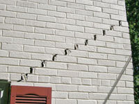 Stair-step cracks showing in a home foundation in Belmont